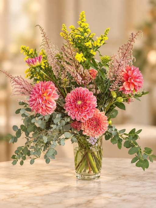 Pink dahlia arrangement displayed in a clear glass vase.