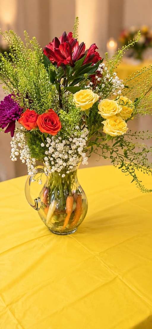 Bright multicolored spring arrangement in a glass pitcher.