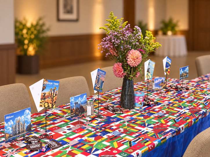 Travel-themed tablescape with globes, maps and mixed florals.