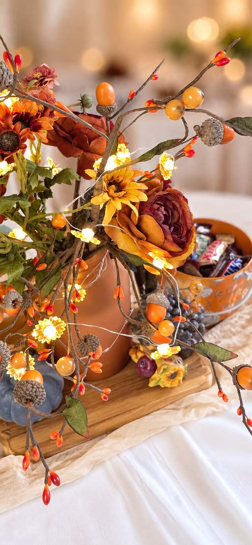 Close view of an autumn centerpiece with fairy lights and acorns.